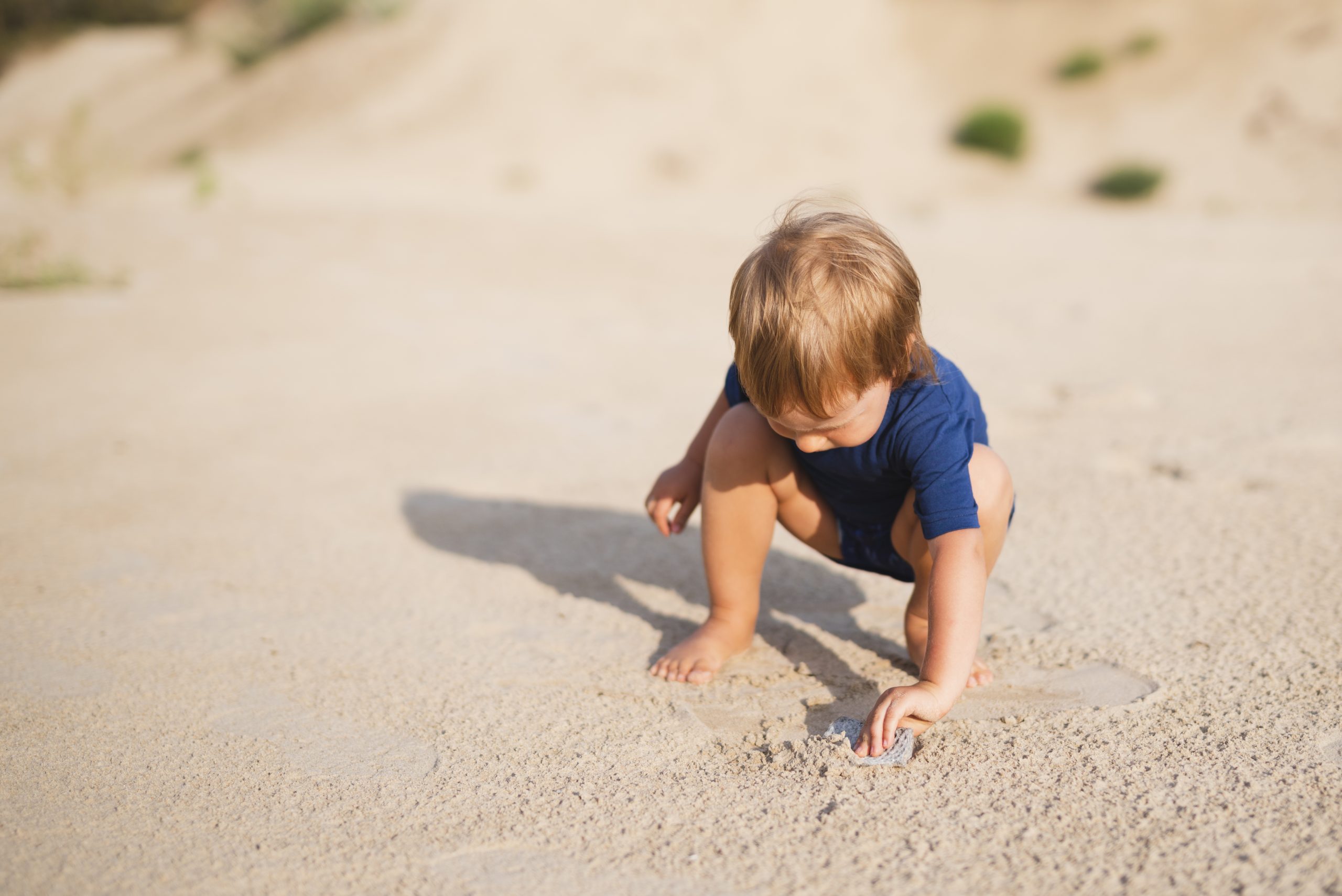 high-angle-little-boy-beach-playing-with-sand